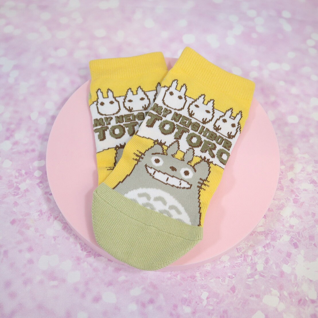 Gula och mörkbeige Totoro-strumpor med grön text